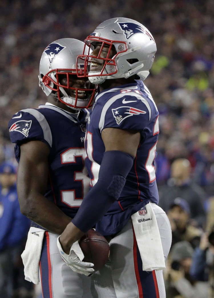Jason McCourty, left, celebrates an interception with Duron Harmon against Minnesota. McCourty has welcomed his role as a leader on and off the field.