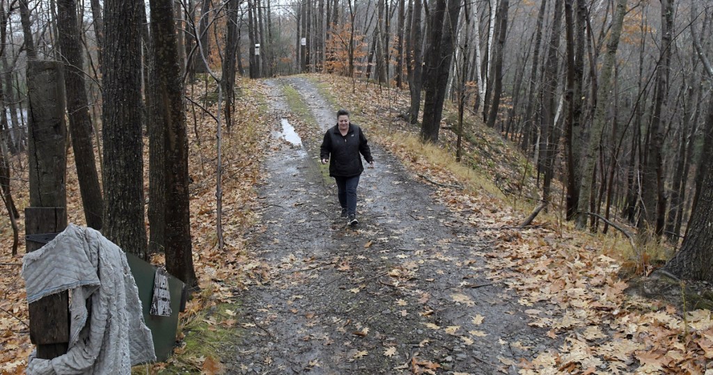 Monique Poulin walks down the road to her home, which faces Boothby Street, on Nov. 13 from pits at the Augusta Public Works facility.