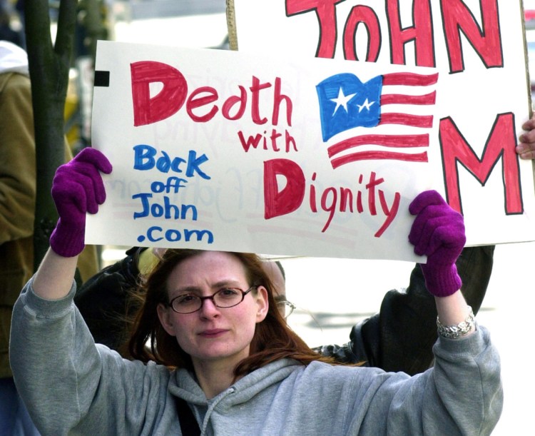 A protester calls for death with dignity during a 2002 hearing on Oregon's assisted-suicide law. A Maine doctor says that in his experience, the fears about such laws aren't valid.