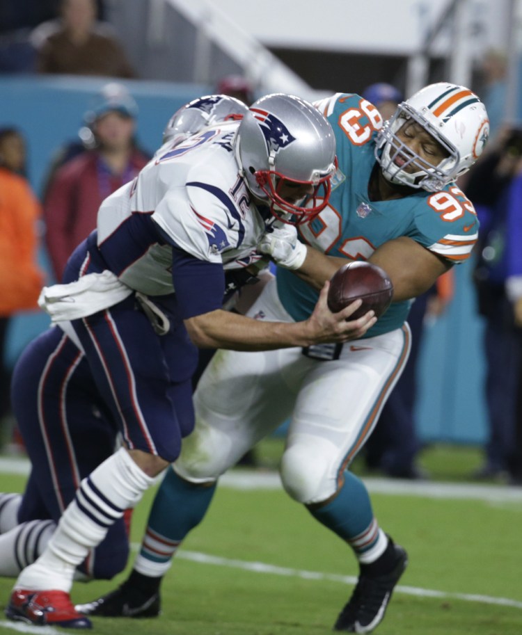 New England Patriots quarterback Tom Brady (12) is sacked by Miami Dolphins defensive tackle Ndamukong Suh (93), during the second half of an NFL football game, Monday, Dec. 11, 2017, in Miami Gardens, Fla. (AP Photo/Lynne Sladky)