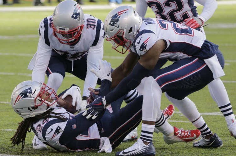 Stephon Gilmore, below, and teammates Duron Harmon, right, and Jason McCourty have had more than just an interception against the Jets to celebrate. The unit has steadily improved after a shaky start to become a key component to the Patriots success.