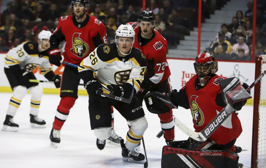 Bruins center Colby Cave pursues a puck flying wide of Ottawa Senators goaltender Mike McKenna during the first period Sunday in Ottawa, Ontario. Boston won 2-1 in overtime despite 42 saves from McKenna, a former Portland Pirate.