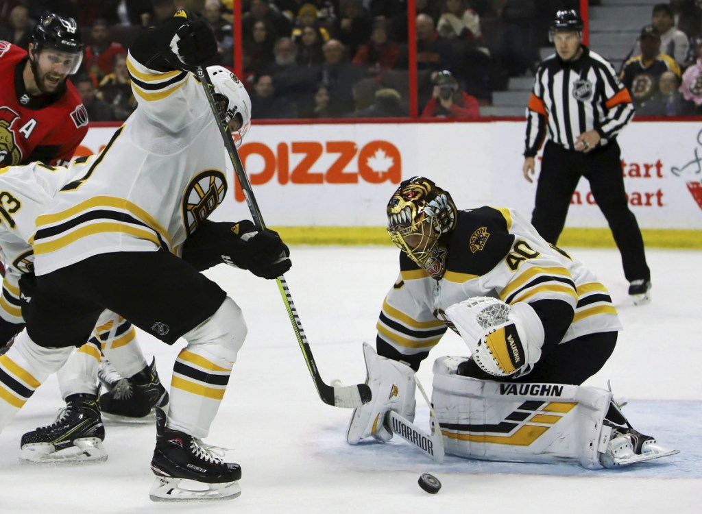 Bruins goalie Tuukka Rask looks to scoop up a loose puck in front of the net during the second period Sunday. Rask made 27 saves, including a key stop on Mark Stone late.