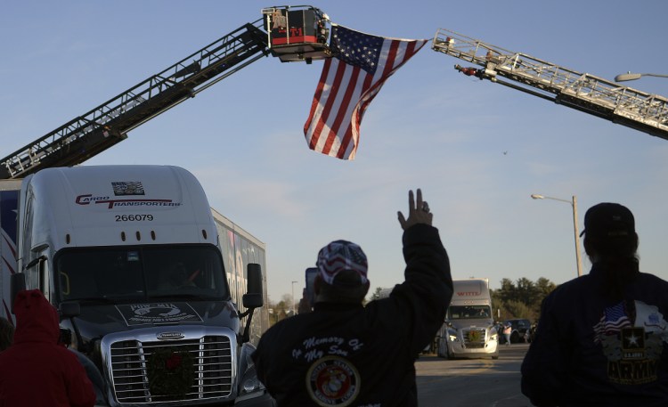 People greet tractor trailers carrying wreaths Sunday at the Augusta Civic Center on the first leg of the Wreaths Across America trip from Maine.