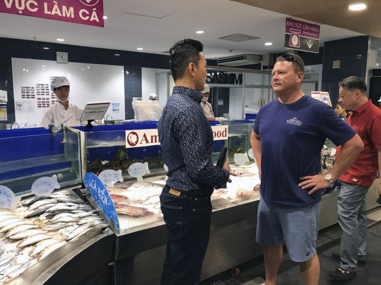Maine Coast lobster dealer Tom Adams talks with a buyer at a Ho Chi Minh City market during a recent trade mission visit to Vietnam. Market-altering "tariffs came on with a flip of the switch," said Adams, "but a new market doesn't. It takes time." 