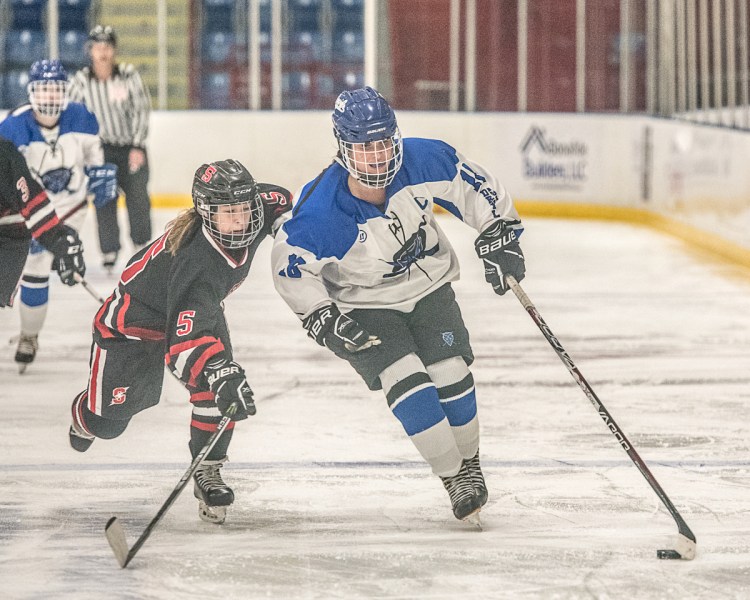 Lewiston's Sara Robert keeps control of the puck as Scarborough's Evelyn Boardman chases behind her during Lewiston's 2-0 win Wednesday night at the Colisee.