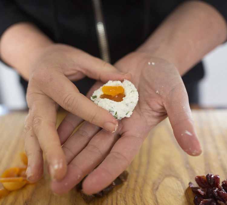 Christine Burns Rudalevige stuffs a ball of goat cheese with dried apricots before coating it with pistachios.