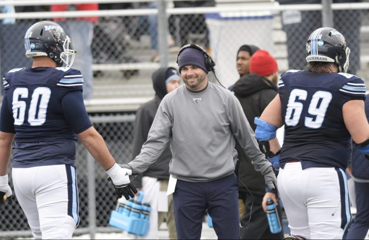 University of Maine coach Joe Harasymiak congratulates players in the game against Jacksonville State on Dec. 1. "I've always loved the environment of the competition, the stress, everything that goes with it," he said.