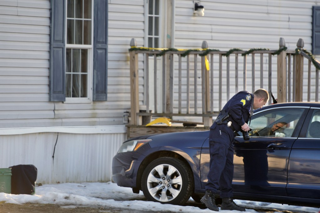 Maine State Police Detective Sgt. Jason Richards examines vehicles outside a residence on the Post Road in Richmond on Saturday.