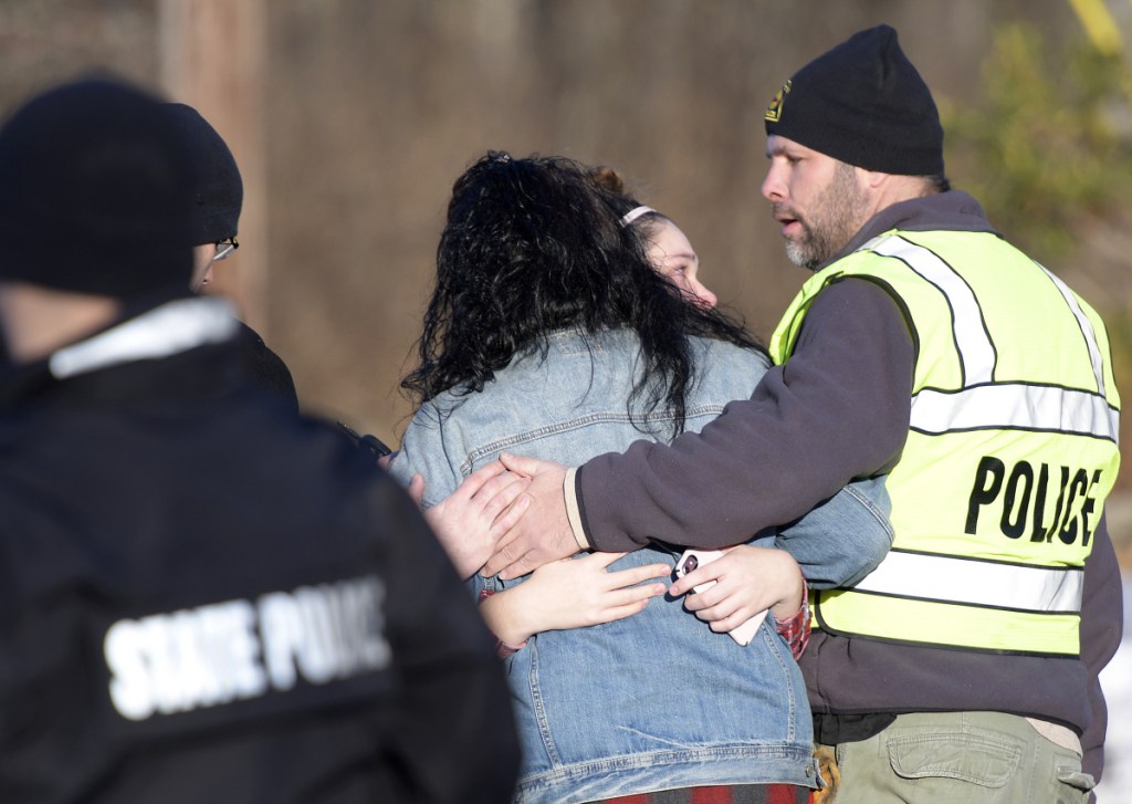 Richmond Police Chief Scott MacMaster comforts relatives of two people found dead Saturday.
