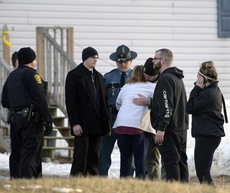 Richmond Police Chief Scott MacMaster comforts relatives of two people found dead Saturday in a residence on Post Road in Richmond. Police said the deaths were "not natural" but there is no threat.