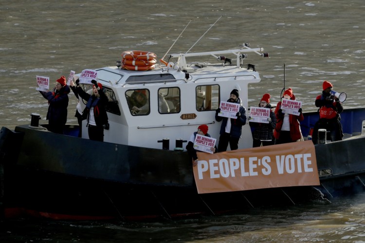 Campaigners mount a protest on a boat calling for a people's vote, a second referendum on Britain's EU membership, on the River Thames outside the Houses of Parliament in London on Thursday.