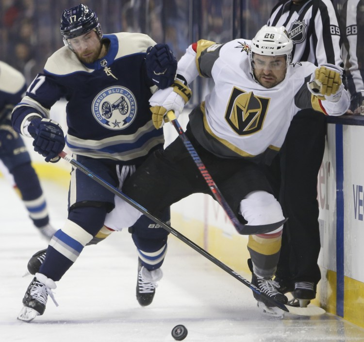 Brandon Dubinsky of Columbus, left, and the Golden Knights' Paul Stastny chase a loose puck during the first period of the Blue Jackets' 1-0 home win Monday.