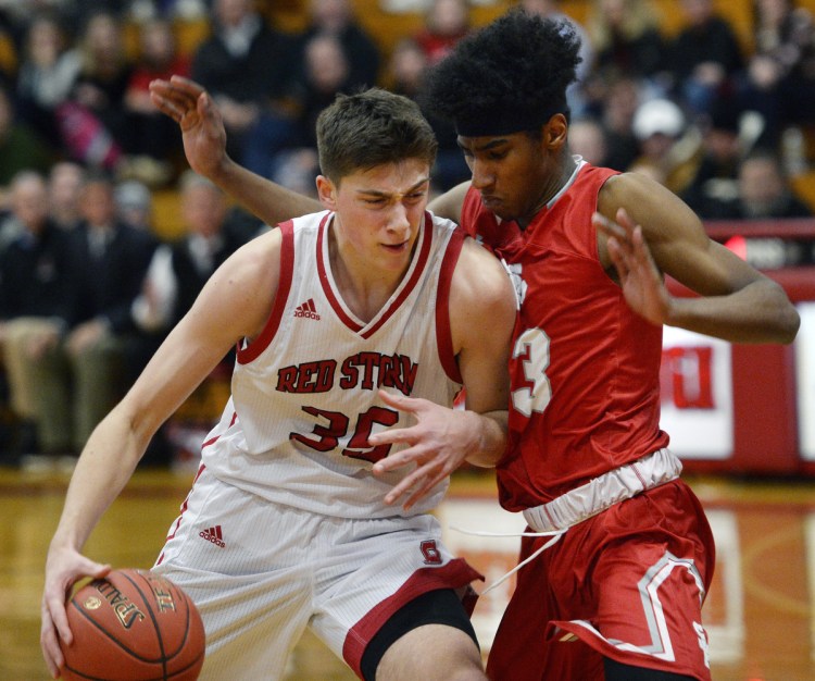 Scarborough's Nick Fiorillo tries to drive to the basket as South Portland's Geremi Baez plays tight defense in Tuesday's game in Scarborough. The Red Riots held Fiorillo to 10 points in a 69-54 win.