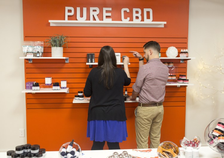 Wellness Connection employees Sarah Anderson and David Theberge label the wider selection of cannabidiol products that the Portland dispensary can now sell under new state regulations. Customers 21 and older can buy hemp products without a medical marijuana card from a doctor.