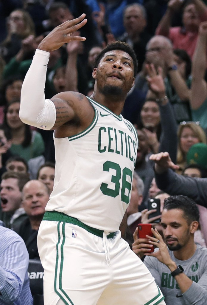 Boston Celtics guard Marcus Smart (36), and fans, celebrate after hitting a 3-point shot to end the second quarter of a basketball game against the Phoenix Suns in Boston, Wednesday, Dec. 19, 2018. (AP Photo/Charles Krupa)