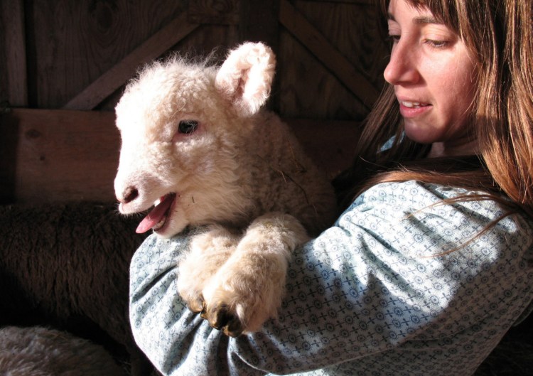 Abby Sadauckas with a lamb at Apple Creek Farm in Bowdoinham.