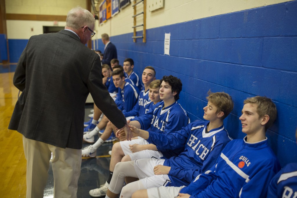 Former Old Orchard Beach basketball coach John Regan greets current players, who are now coached by Regan's son, Matt.