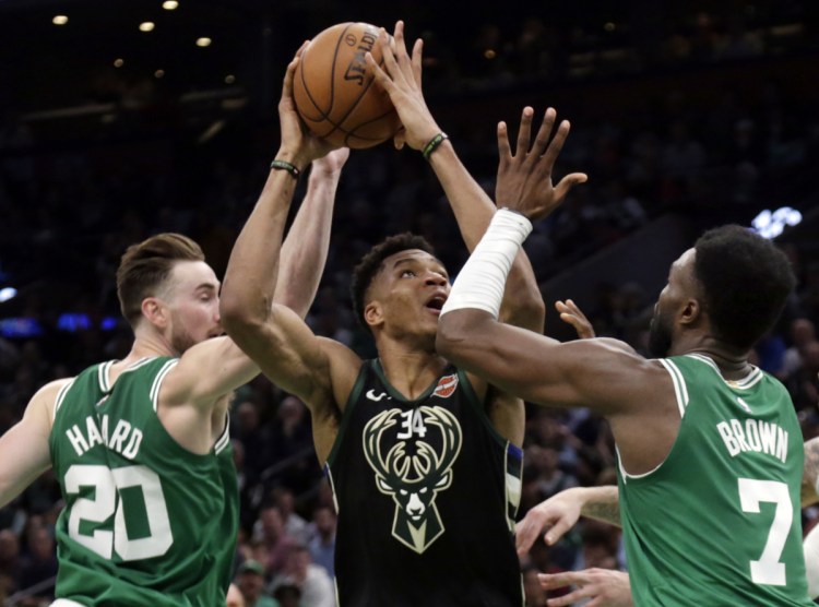 Milwaukee forward Giannis Antetokounmpo goes to the hoop against Boston Celtics forward Gordon Hayward, left, and guard Jaylen Brown in the second quarter Friday in Boston.