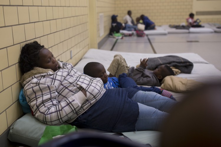 A mother and son sleep on mats at the Salvation Army gym. Portland's head of social services says the number of asylum seekers is now a "crisis situation."