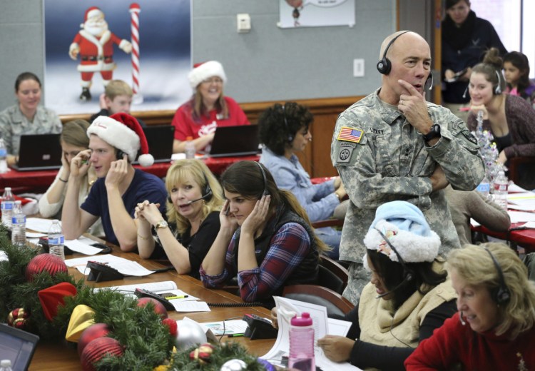 NORAD Chief of Staff Maj. Gen. Charles D. Luckey takes a call while volunteering at the NORAD Tracks Santa center at Peterson Air Force Base in Colorado Springs, Colo., in 2014. Hundreds of volunteers will help answer phone calls from children around the world calling for Santa when the program resumes on Monday for the 63rd year. 