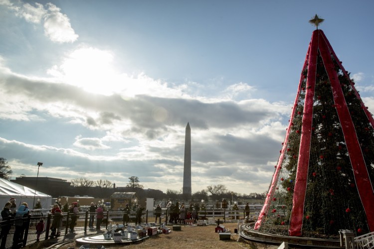 Visitors to the national Christmas tree look at holiday decorations Monday as National Park Service employees briefly open the venue before closing it again because of electrical problems. Repairs were delayed because of a partial government shutdown over funding for President Trump's U.S.-Mexico border wall.