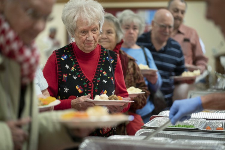 Donna Ames, 83, of Portland waits in the serving line at a Christmas day meal at Westbrook-Warren Congregational Church in Westbrook on Tuesday. "It's just great," she said. "They do a great job and the people here are just wonderful." She was dining before her night shift at Spring Harbor Hospital.
