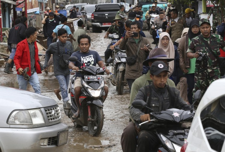 People flee in panic Tuesday in Sumur on Java in Indonesia, after a false report of another tsunami.