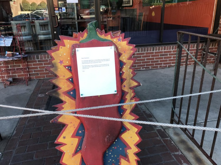 The note on the chili pepper sandwich board in front of Federal Spice says the restaurant closed for good on Christmas Eve.