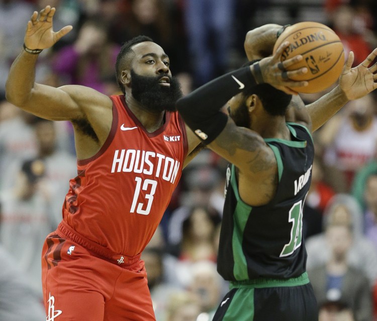 Houston Rockets guard James Harden applies defensive pressure against Boston Celtics guard Kyrie Irving during the first half of the Rockets' 127-113 win Thursday in Houston.