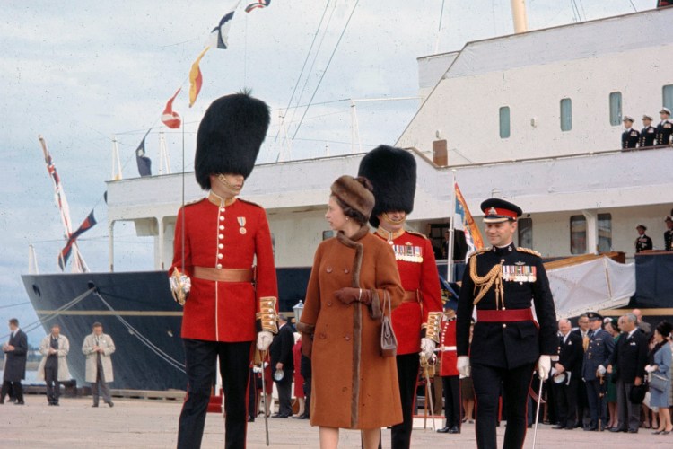 Queen Elizabeth II is escorted by Capt. G.L. Simpson as she leaves the Royal Yacht Britannia in 1964 in Charlottetown, Canada. The Royal Yacht Britannia was in service from 1954 to 1997.