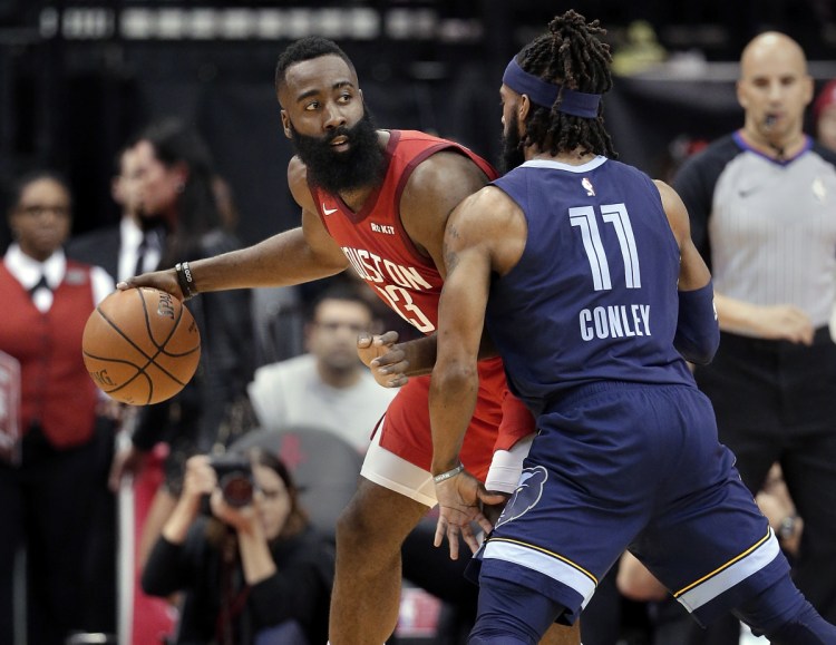 Houston guard James Harden looks to pass the ball under pressure from Memphis guard Mike Conley during the first half Monday in Houston.