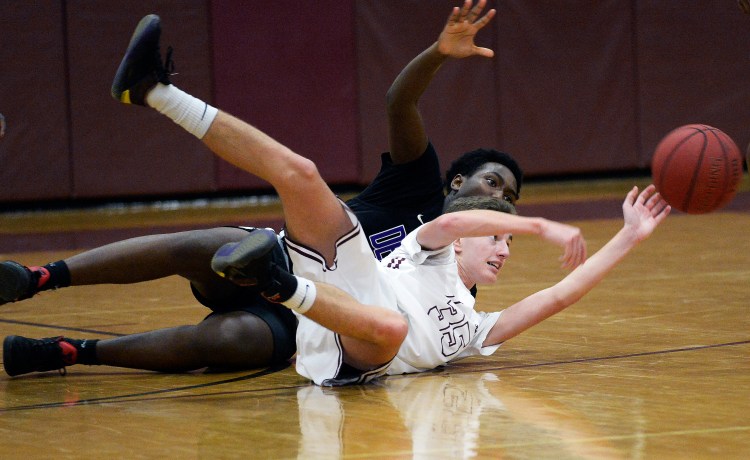 Gorham's Nick Strout makes a pass from the floor after coming up with a loose ball as Deering's Mpore Semuhoza plays defense during Deering's 61-58 win Monday in Gorham.