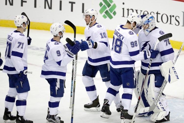 Tampa Bay Lightning goaltender Louis Domingue, far right, celebrates with defenseman Mikhail Sergachev (98) and teammates after the Lightning beat the Devils 5-1 on Monday in Newark, New Jersey.