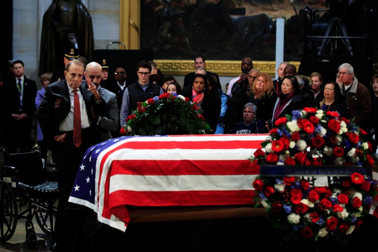 Former Sen. Bob Dole salutes the flag-draped casket containing the remains of former President George H.W. Bush at the U.S. Capitol in Washington on Tuesday.