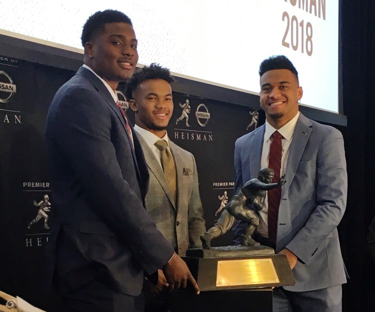 Heisman Trophy finalists, from left, Dwayne Haskins, from Ohio State, Kyler Murray, of Oklahoma, and Tua Tagovailoa, from Alabama, pose with the Heisman Trophy at the New York Stock Exchang on Friday in New York.