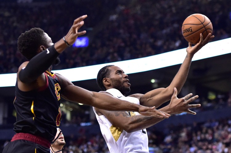 Toronto Raptors forward Kawhi Leonard, right, drives to the basket as Cleveland Cavaliers guard Rodney Hood, left, defends during second-half NBA basketball game action in Toronto, Friday, Dec. 21, 2018. (Frank Gunn/The Canadian Press via AP)