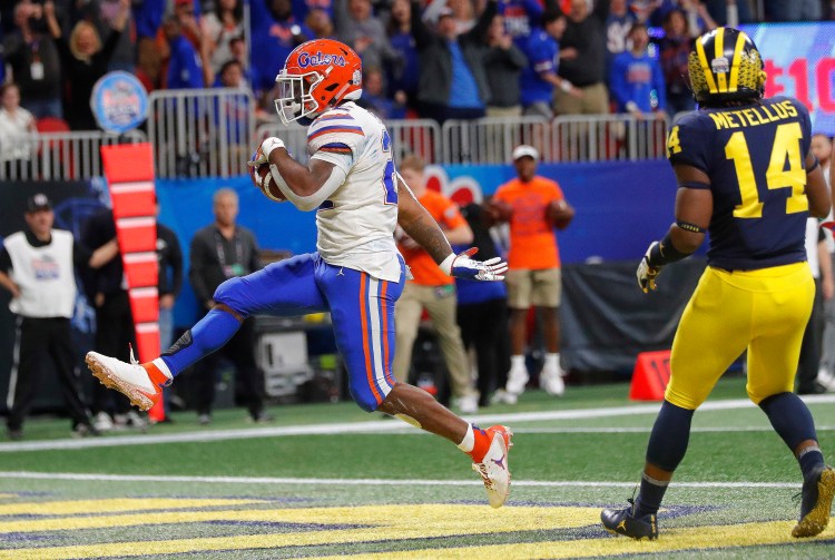Florida running back Lamical Perine (22) runs into the end zone for a touchdown against Michigan during the first half of the Peach Bowl on Saturday in Atlanta.