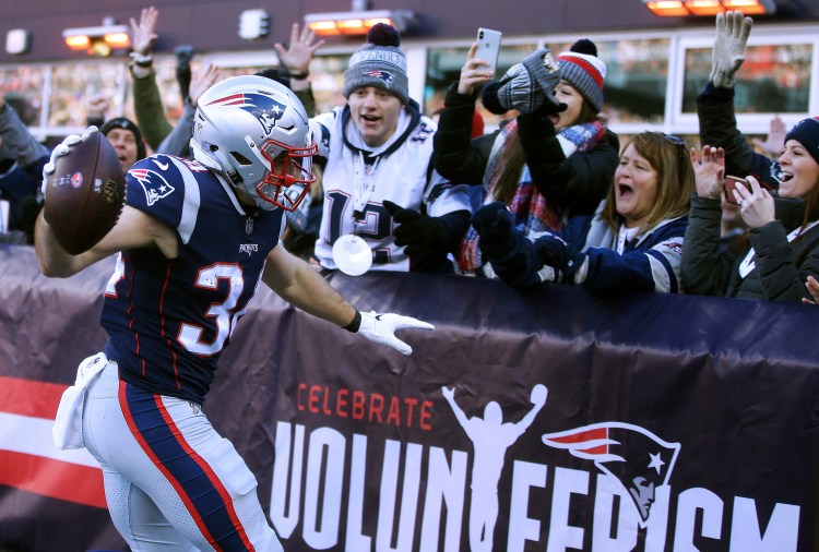 New England Patriots running back Rex Burkhead celebrates his touchdown with fans in the end zone stands during the first half of the Patriots' 38-3 win over the Jets that gave the Patriots a first-round bye.