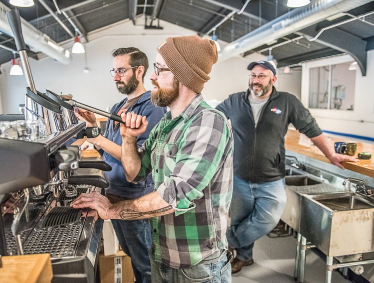 Nathan Hahn, left, of Coffee By Design walks Willis Croninger through the process of pulling the first press of espresso at Side By Each Brewing Co. in Auburn, as owner Ben Low looks on, right. The business will open in January with coffee and beer sampling. 