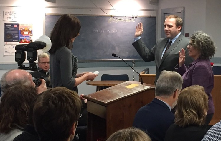 New South Portland City Councilors Misha Pride and April Caricchio are sworn in by City Clerk Emily Scully on Monday.