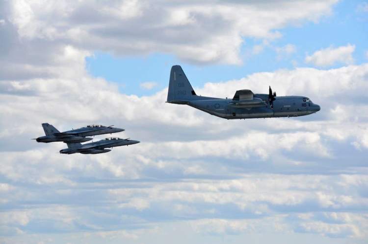 Two U.S. Marine Corps F/A-18 Hornets and a KC-130J Hercules fly during a demonstration in September.