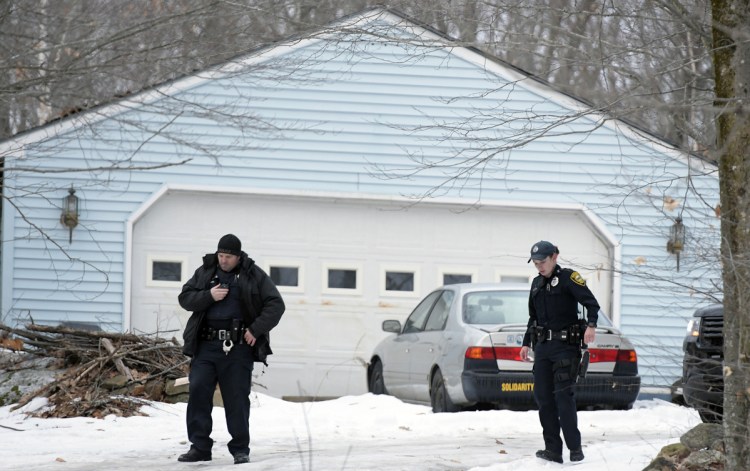 Augusta Police officers Don Whitten, left, and Sara Rogers search near a residence Sunday on Route 105 in Augusta following a report of shots fired. Several officers searched the residence before turning the building over to detectives. Augusta Police Sgt. Chris Shaw said the incident remains under investigation.