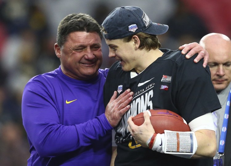LSU Coach Ed Orgeron, left, celebrates with quarterback Joe Burrow, right, after the Tigers beat Central Florida 40-32 in the Fiesta Bowl on Tuesday in Glendale, Arizona.