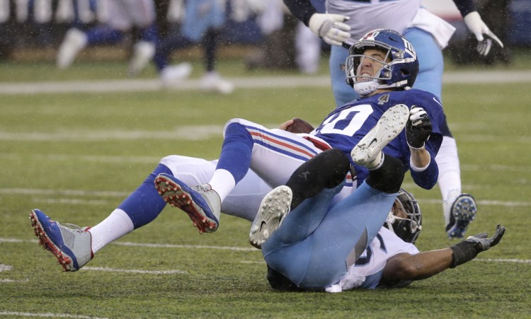 New York Giants quarterback Eli Manning, top, was battered and bruised this season, and on Wednesday did not get a vote of confidence from General Manager Dave Gettleman, who would not say if the team will bring back Manning for a 16th season.