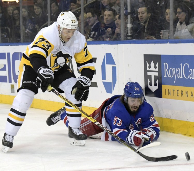 Penguins defenseman Jack Johnson pokes the puck away from Rangers center Mika Zibanejad in the second period Wednesday night in New York. The Penguins won their seventh straight, 7-2.