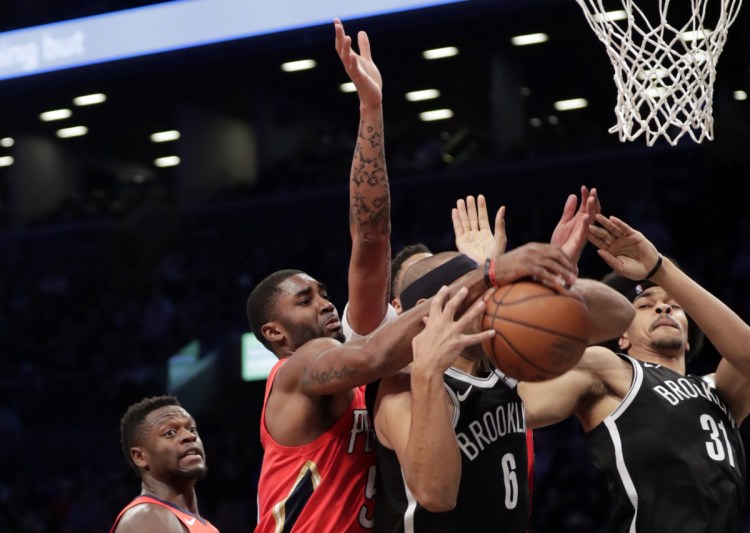 E'Twaun Moore of the Pelicans fights for control of the ball with Brooklyn's Jared Dudley during the first half Wednesday night in Brooklyn.