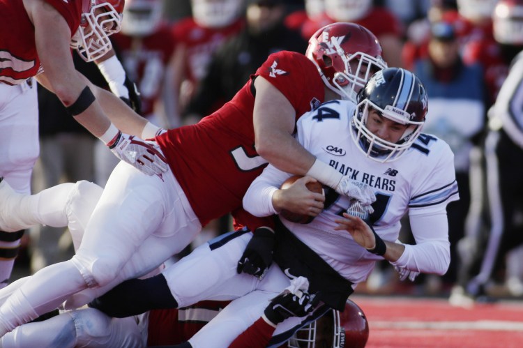 Eastern Washington defensive lineman Mitchell Johnson, left, sacks Maine quarterback Chris Ferguson during the first half of an NCAA college football FCS semifinal game in Cheney, Wash., Saturday, Dec. 15, 2018. (Photo by Young Kwak)