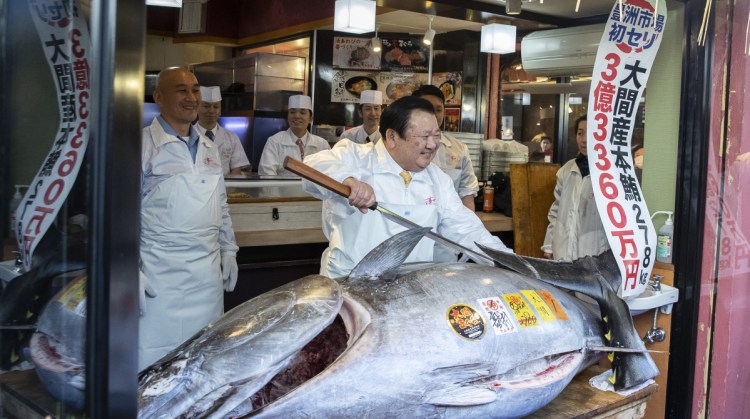 Kiyoshi Kimura, president of Kiyomura Corp., poses with a newly purchased bluefin tuna at a Sushizanmai restaurant in Tokyo on Saturday. The record price was more than double the previous high set for a bluefin in 2013.