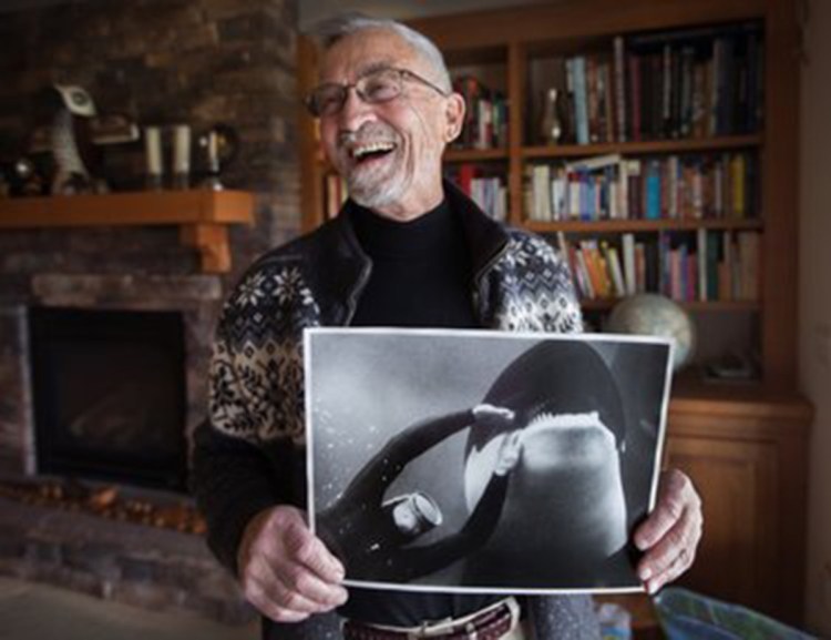 Ted Griffin, the first to capture and befriend an orca in Puget Sound in 1965, holds a photo by National Geographic of him with Namu. His actions set off a craze for killer whales that would imperil the species.